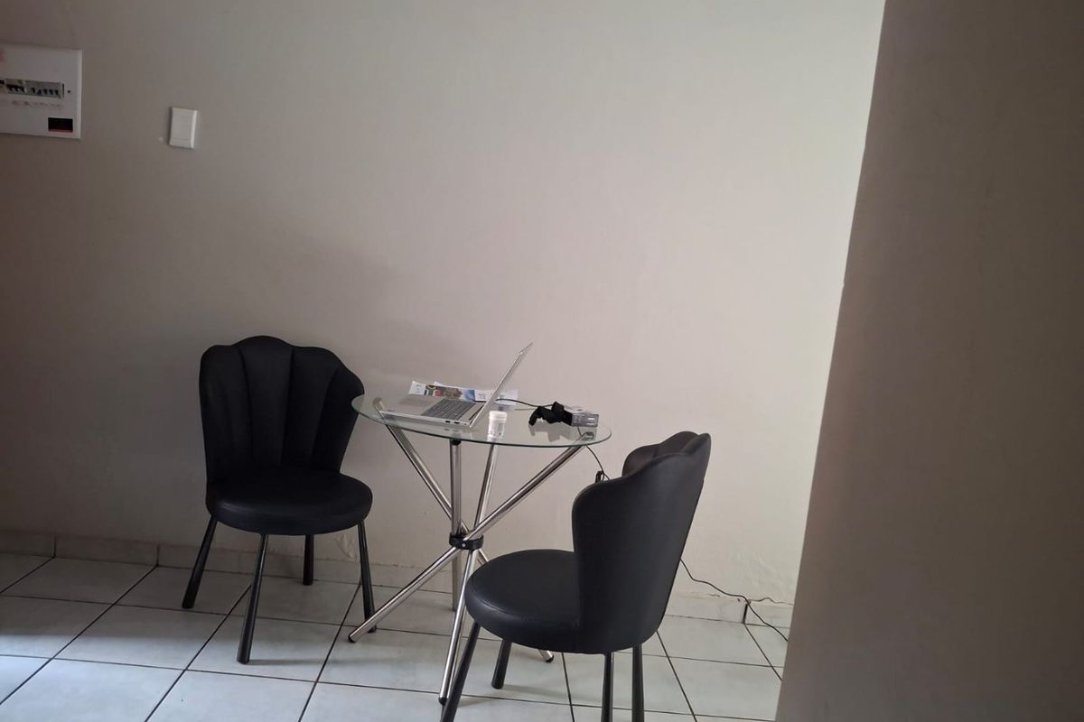 A small living area featuring ceramic floor tiles and a wall-mounted electrical distribution board.
