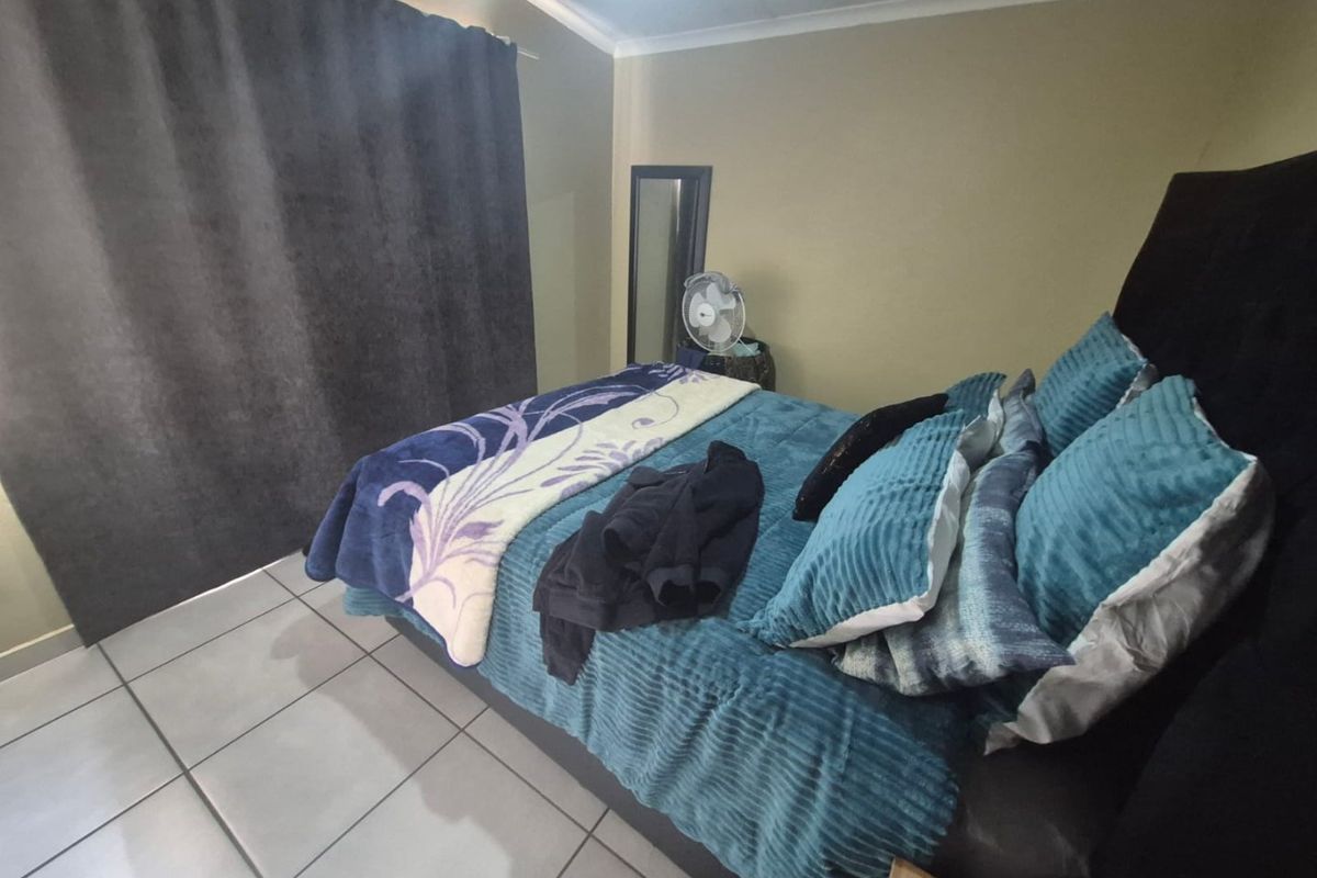 A bedroom featuring tiled flooring and a sliding door providing access to the exterior.
