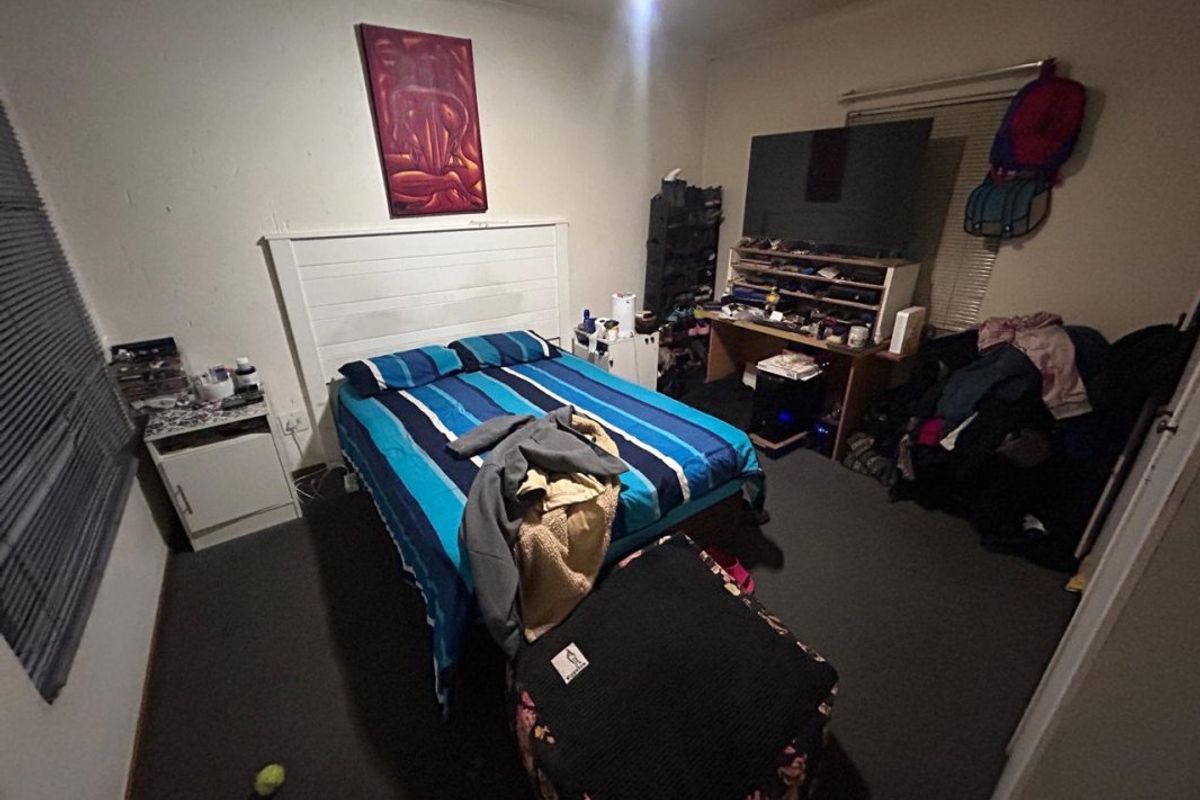 A standard bedroom featuring carpet flooring and venetian blinds, offering a functional space for rest.