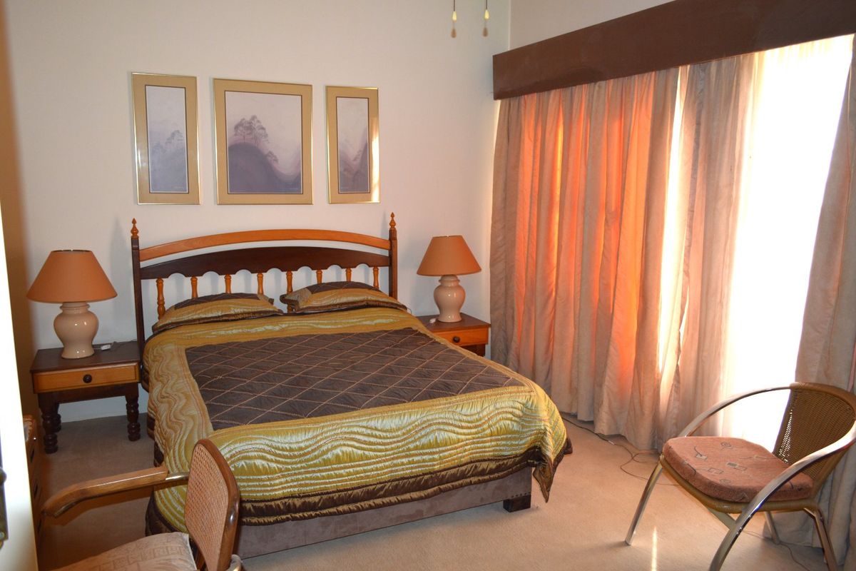 A standard bedroom featuring carpeted flooring and a curtain pelmet, providing a functional space with natural light access.