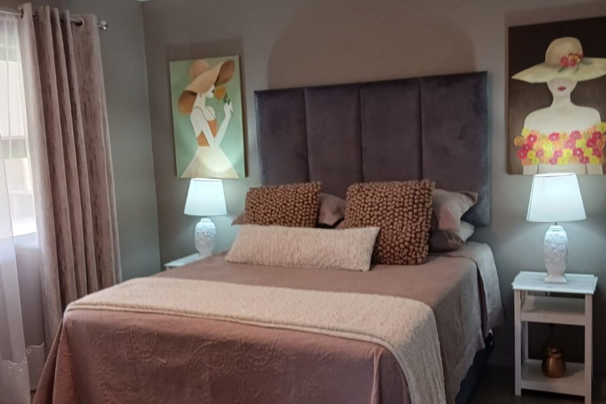 A well-maintained bedroom featuring a modern ceiling fan and neutral tiled flooring, creating a comfortable and inviting sleeping space.