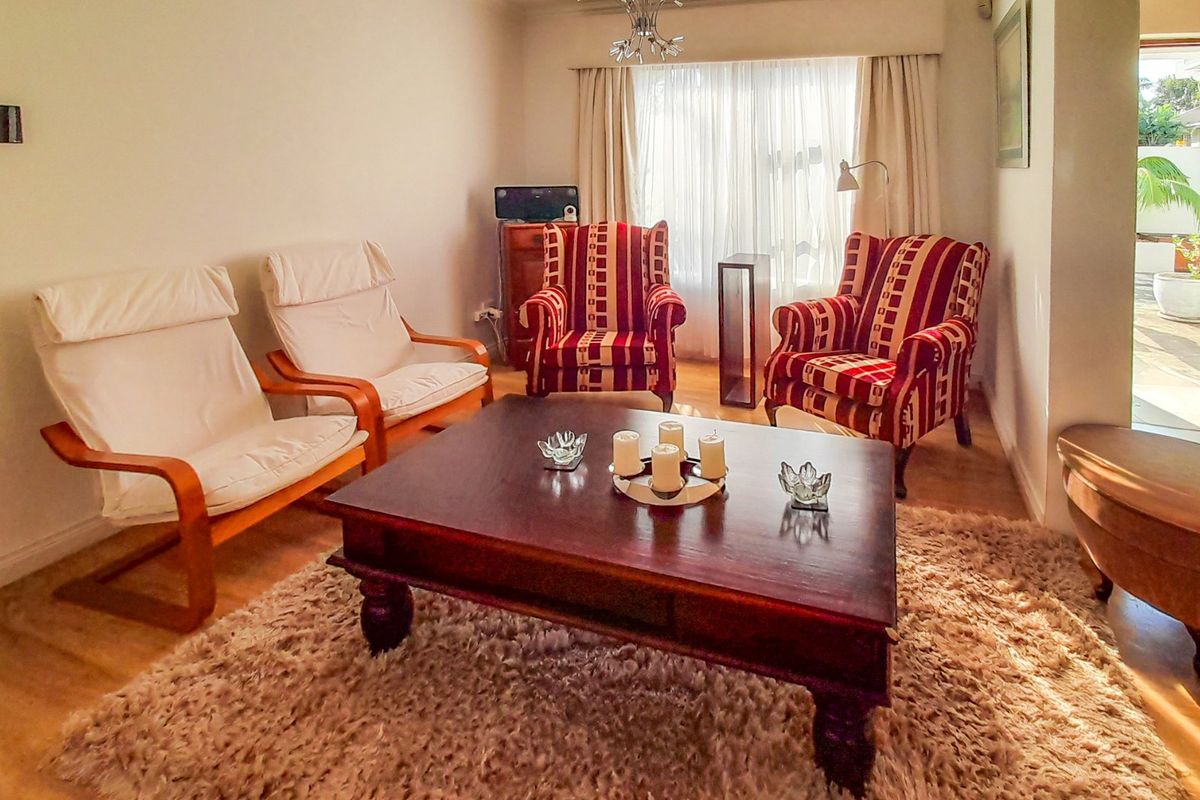 A comfortable living room featuring laminate flooring and natural light, with direct access to an outdoor patio area.
