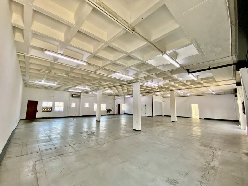 Spacious industrial utility area featuring a waffle slab ceiling, concrete flooring, and structural support columns, suitable for warehouse or workshop use.