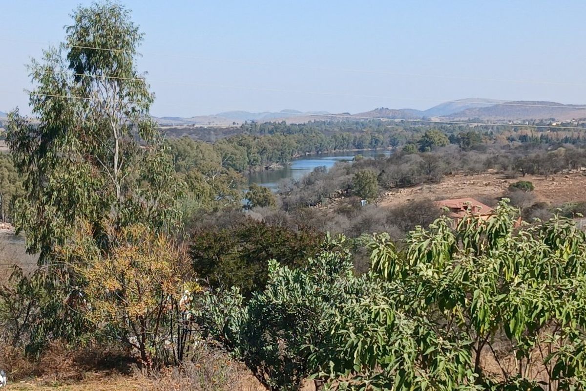 A scenic landscape view overlooking a river and surrounding natural vegetation, showcasing the tranquil environment of the property.