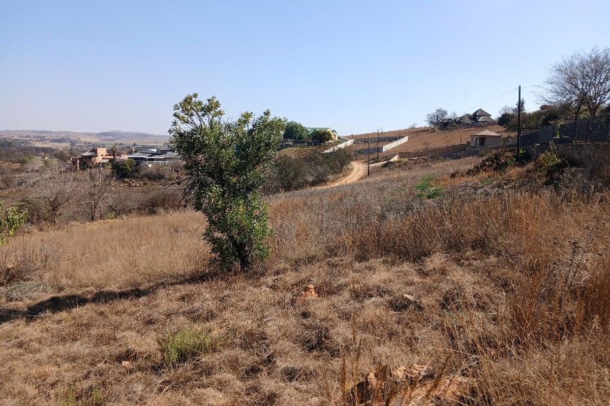 A view of the vacant residential land showing the natural sloped terrain and surrounding landscape.