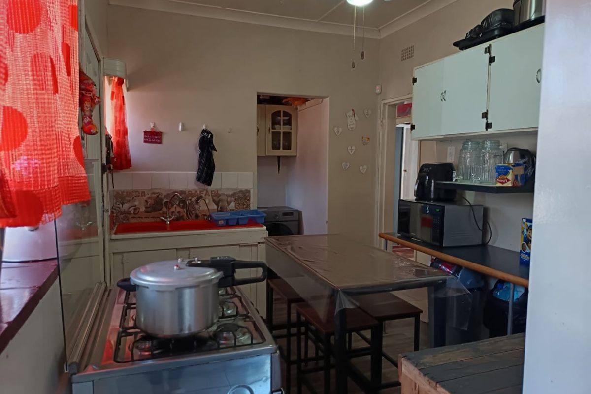 A functional kitchen featuring dated cabinetry, a gas stove, and a tiled splashback, offering potential for modernization and layout optimization.