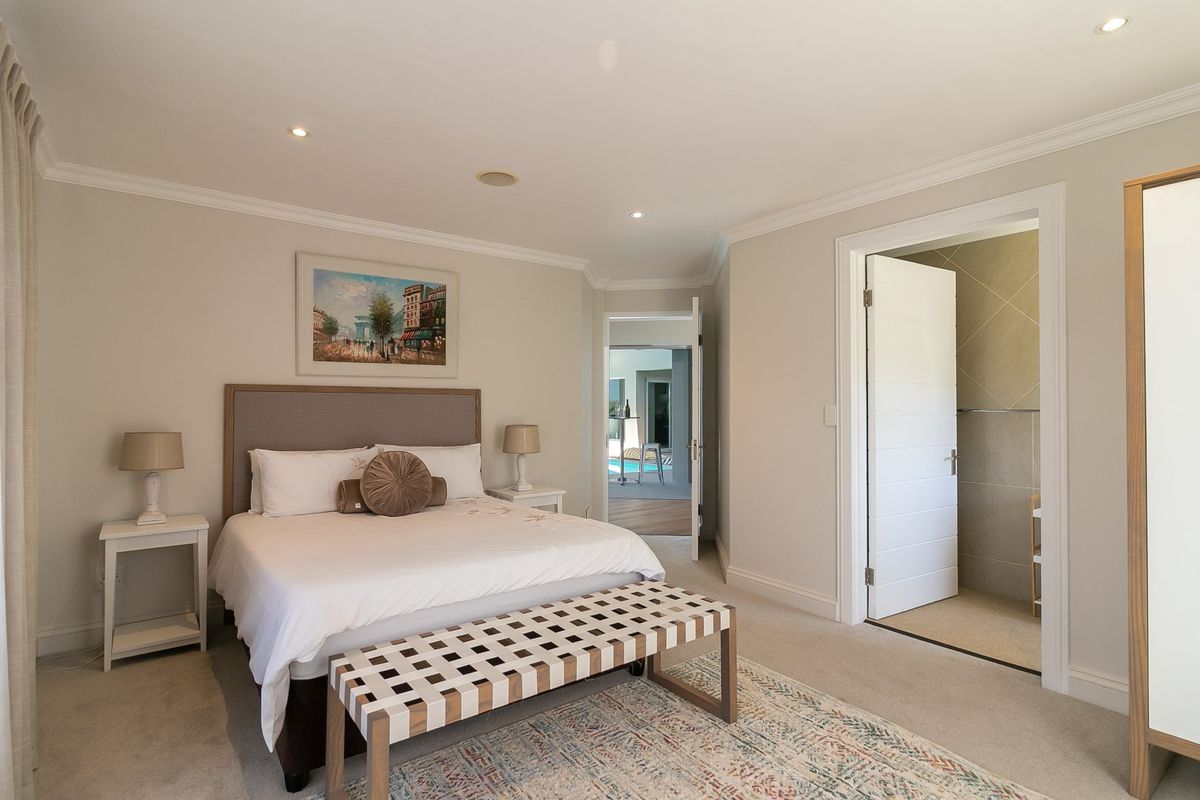 Spacious bedroom featuring neutral tones, recessed lighting, coving, and direct access to an en-suite bathroom.