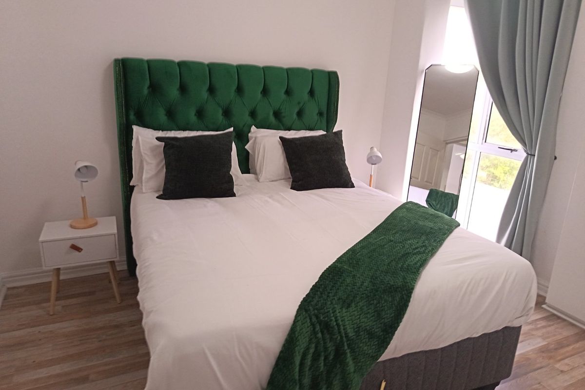 A well-maintained bedroom featuring light-toned laminate flooring and a window with natural light, providing a comfortable and inviting sleeping space.