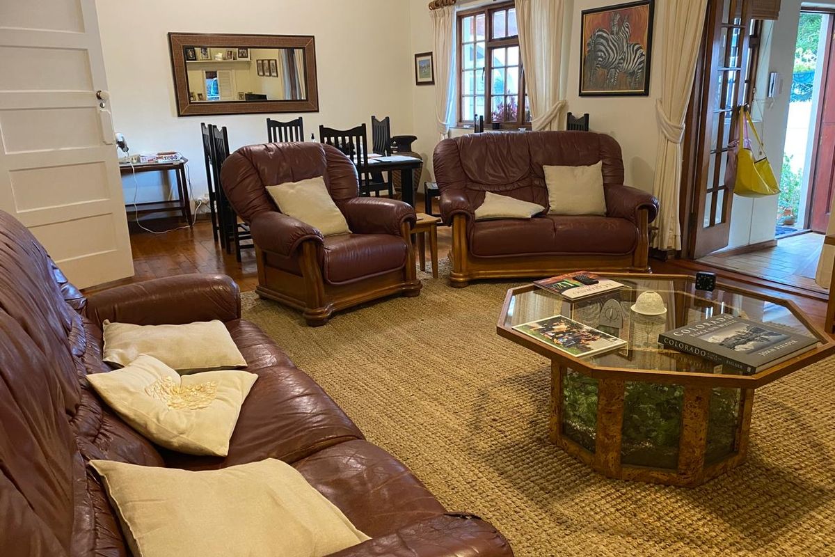 A comfortable living room featuring warm hardwood flooring and timber-framed windows, providing a classic and inviting atmosphere.