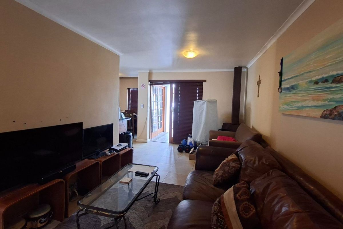 A living room featuring tiled flooring, a fireplace, and a sliding glass door providing access to the outdoor area.