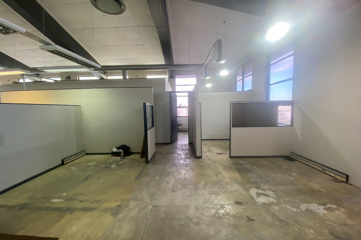Open-plan commercial office space featuring exposed industrial ductwork, partition walls, and concrete flooring, offering a blank canvas for custom fit-out.