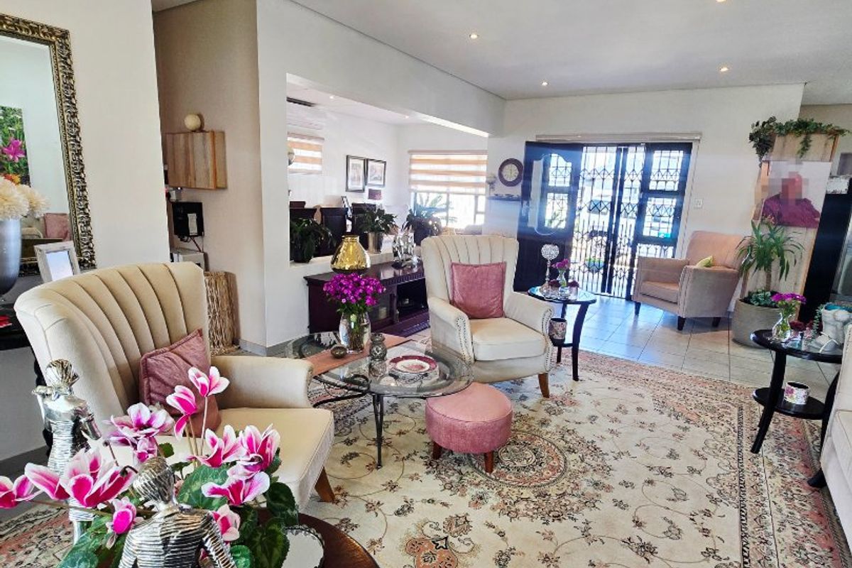 Spacious living area featuring tiled flooring, recessed downlighting, and a secure entrance with a decorative security gate.
