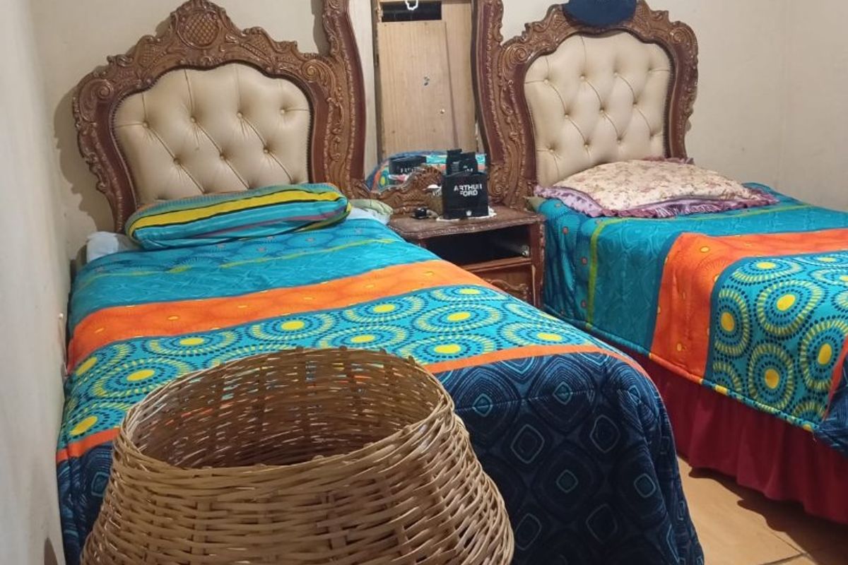 A bedroom featuring a shared headboard design with an integrated central mirror.