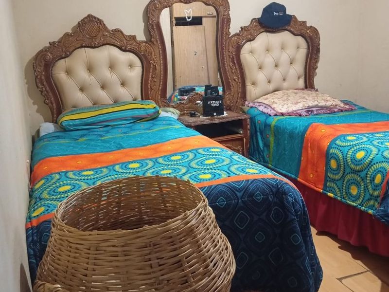 A bedroom featuring a shared headboard design with an integrated central mirror.