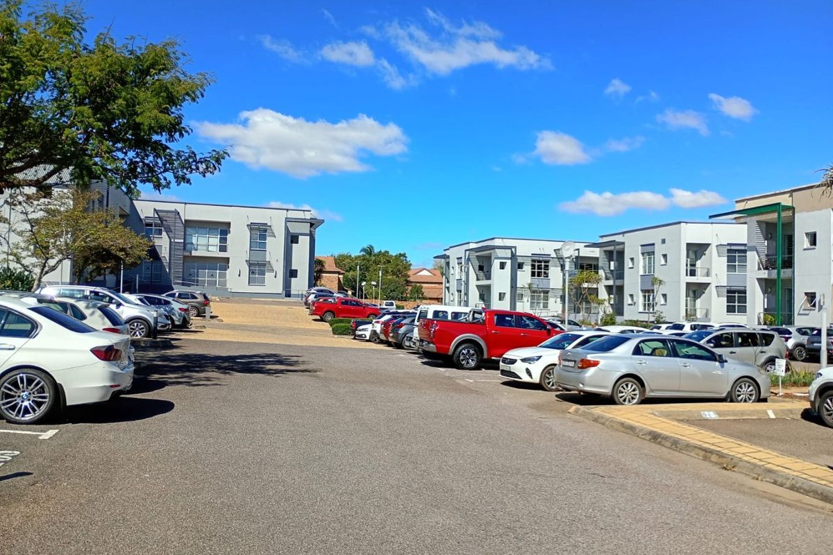 A view of the commercial property exterior featuring a paved parking area and multi-story office buildings under a clear sky.