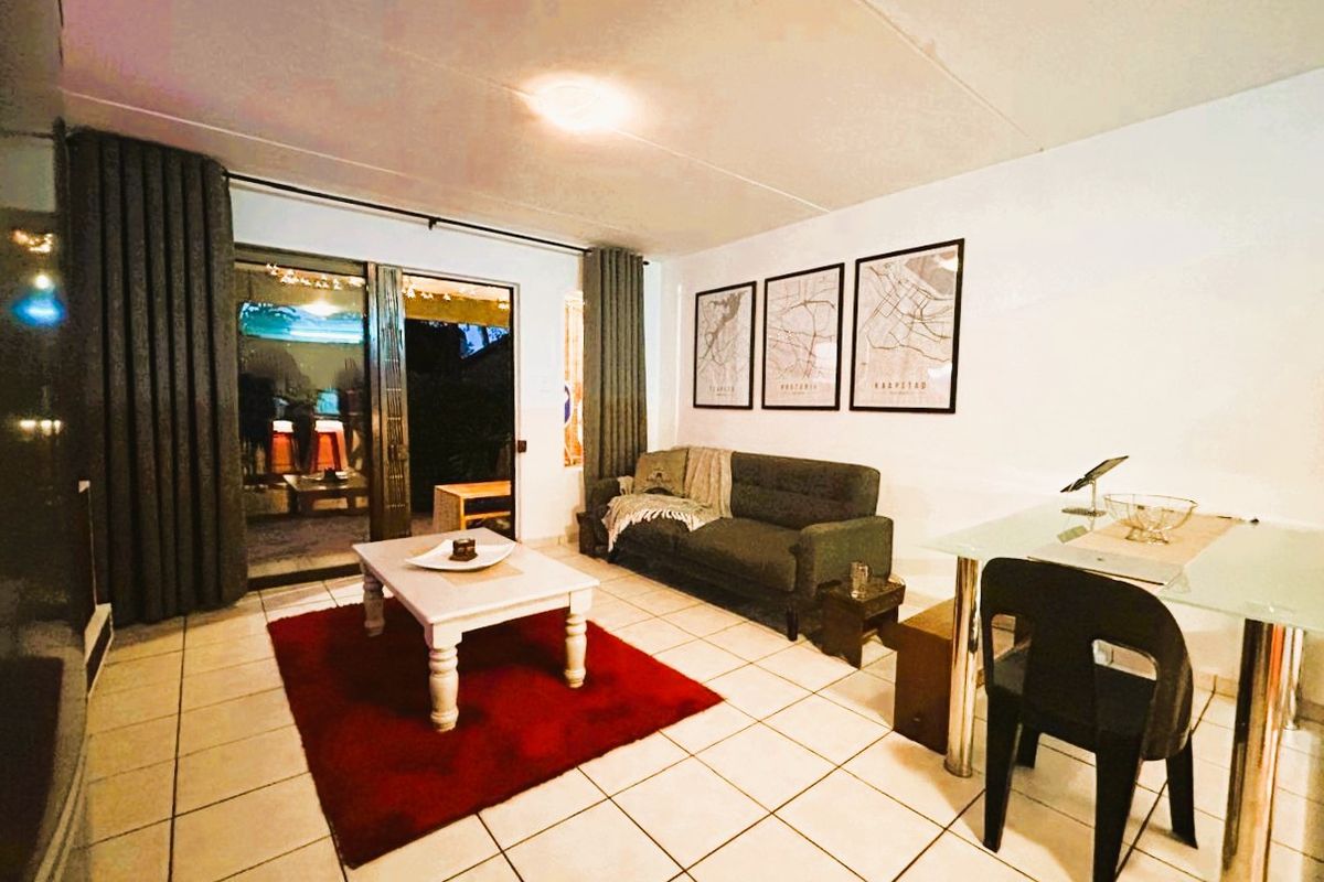 A living room featuring tiled flooring and a sliding glass door providing access to an outdoor area.