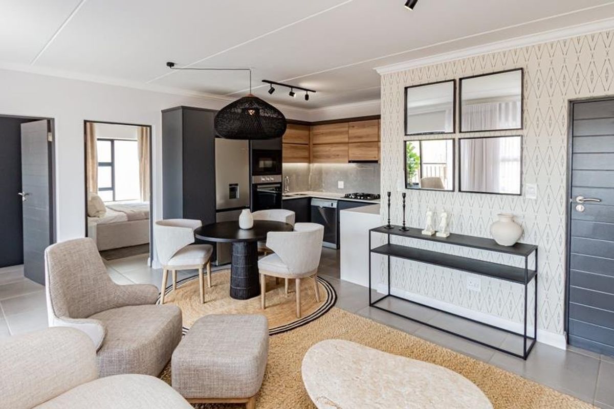 Modern open-plan living and kitchen area featuring contemporary cabinetry, integrated appliances, tiled flooring, and neutral finishes throughout the well-maintained space.