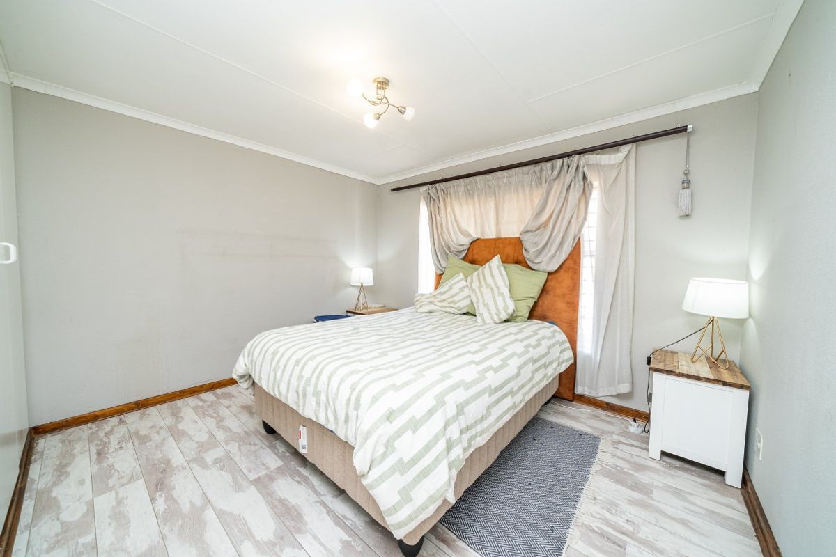 A bedroom featuring light-toned wood-look flooring and neutral wall finishes, providing a functional space ready for personalization.