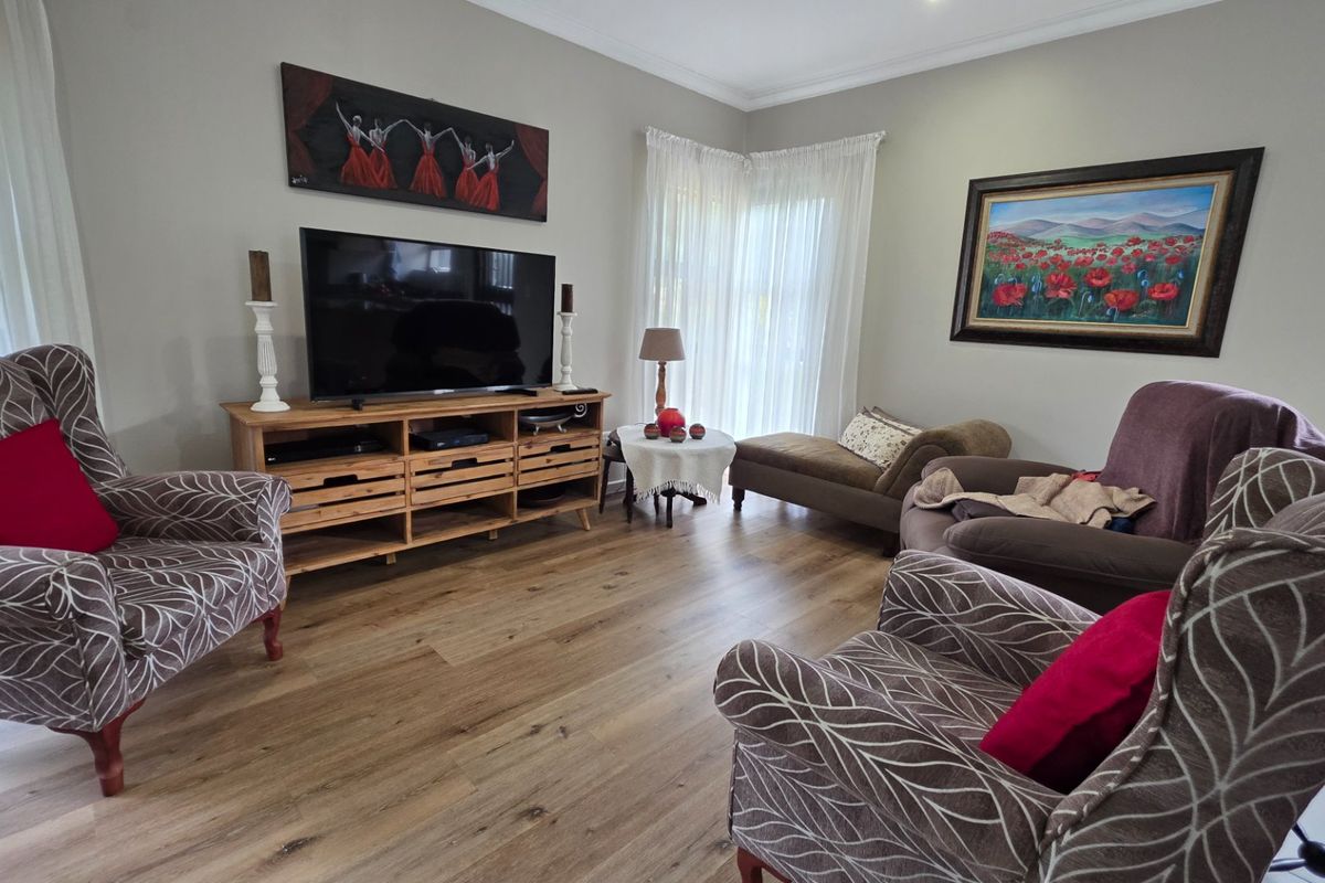 A comfortable living room featuring durable laminate flooring, neutral wall tones, and recessed downlighting, creating a warm and inviting atmosphere.