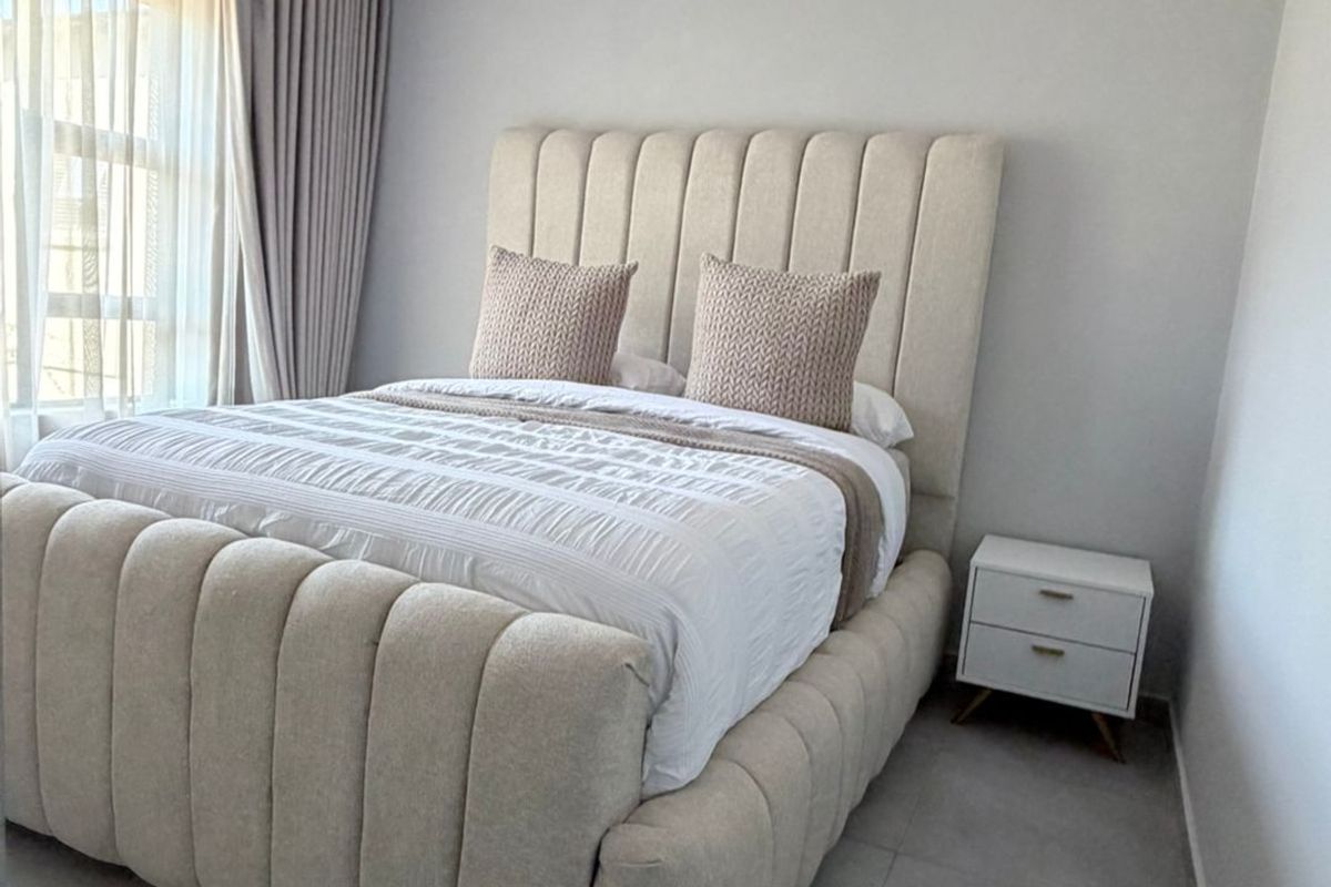 A well-maintained bedroom featuring neutral tiled flooring, a tongue and groove ceiling with recessed lighting, and floor-to-ceiling curtains.