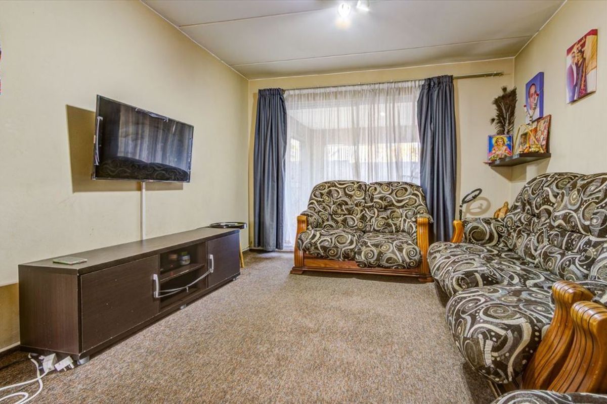 A living room featuring carpeted flooring and a sliding glass door providing access to the exterior, offering a functional and comfortable living space.