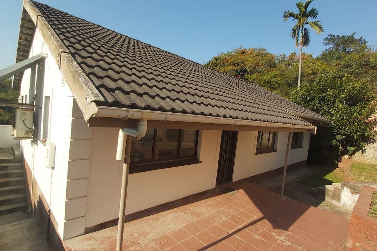 Rear view of the house featuring a tiled patio area, pitched roof, and external wall finishes.