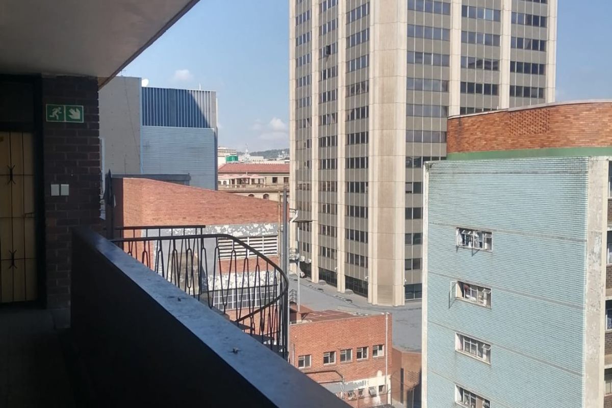 A functional balcony area overlooking an urban cityscape with surrounding high-rise buildings.