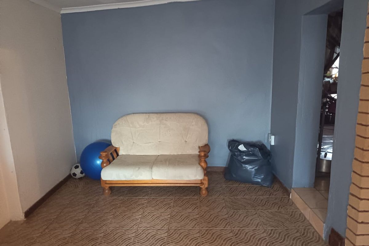 A living room area featuring tiled flooring and painted walls, providing a basic foundation for potential interior updates and styling.