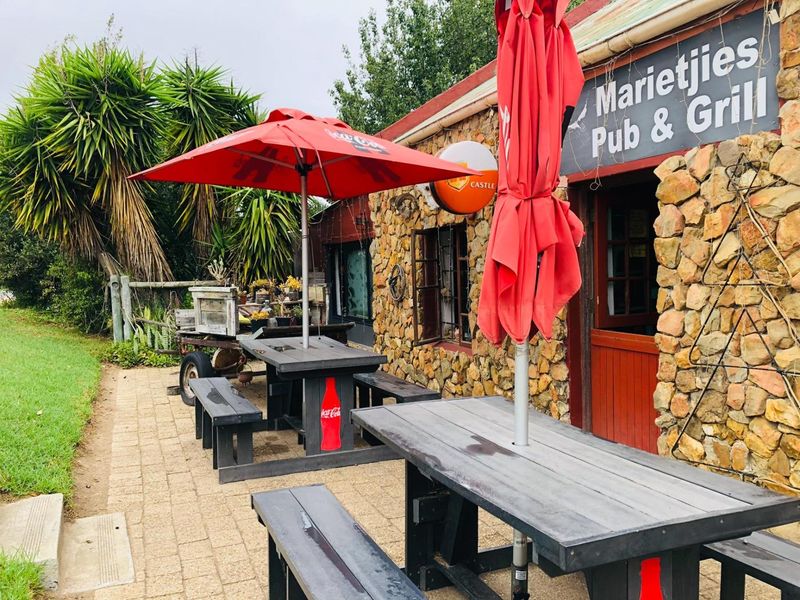 Outdoor patio area featuring stone-clad exterior walls and paved flooring, serving as an entrance to the pub and grill establishment.