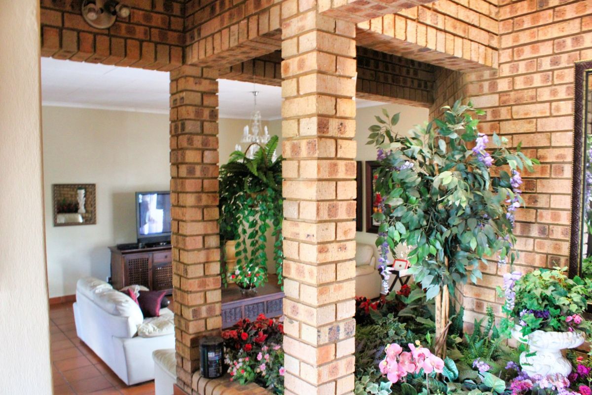 A living area featuring distinctive exposed brick columns and archways, creating a rustic architectural divide between the main lounge space and adjacent areas.