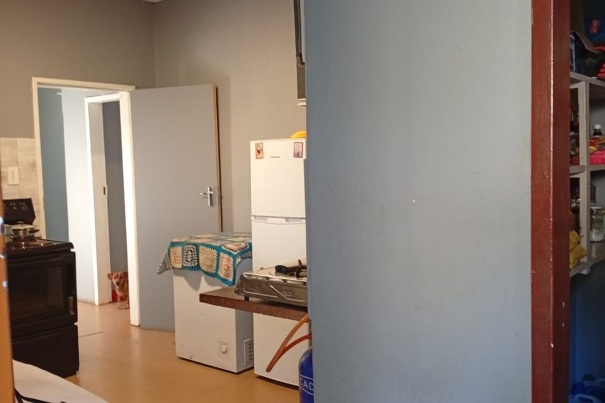 A functional kitchen area featuring tiled flooring and built-in oven, showing signs of wear and requiring cosmetic updates.