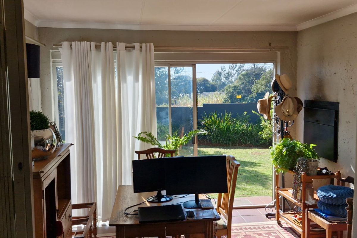 A living area featuring tiled floors, a built-in fireplace, and large sliding glass doors providing direct access to the garden.