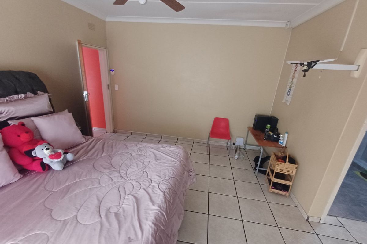 A bedroom featuring ceramic floor tiles, a ceiling fan, and coved cornice detailing.