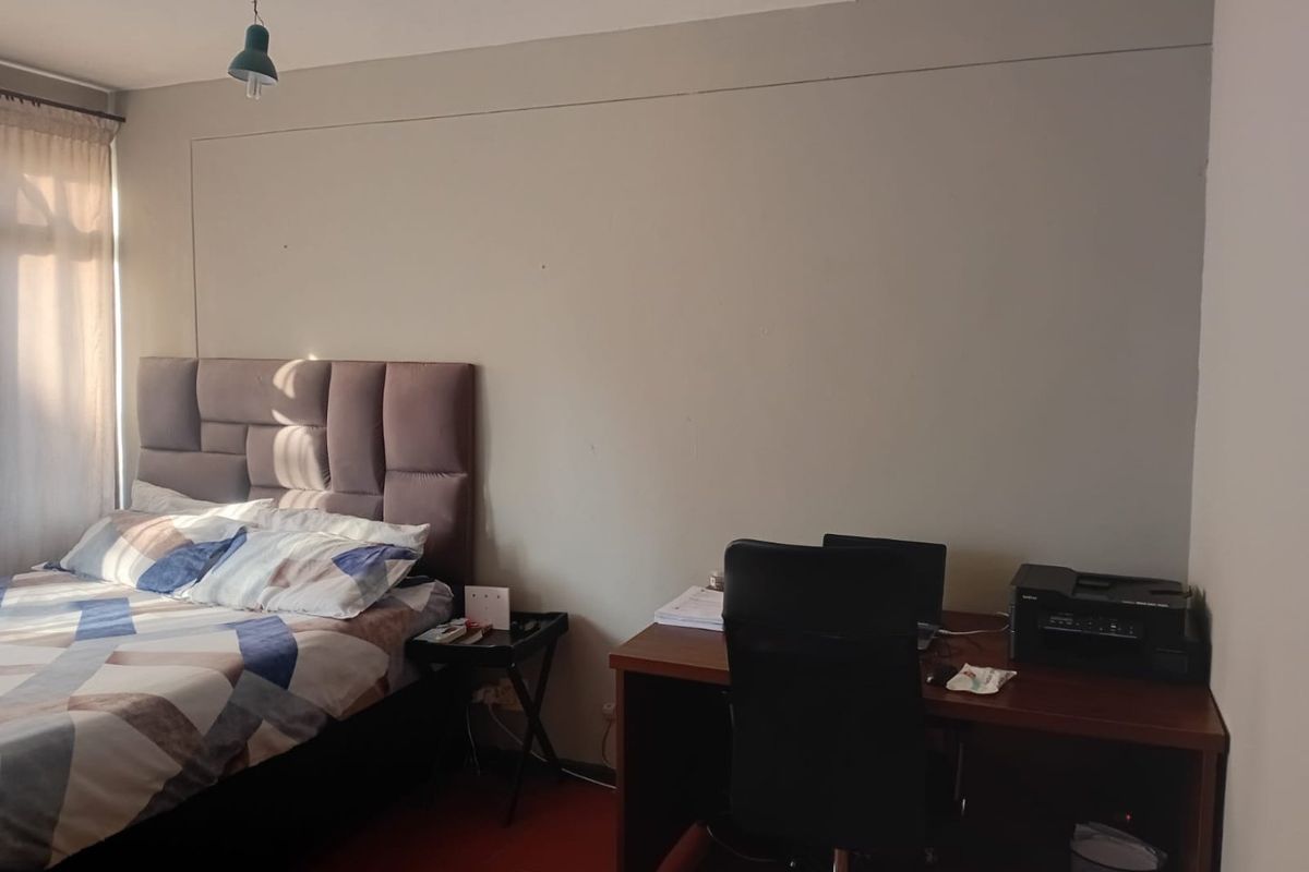 A bedroom featuring neutral wall finishes and natural light from the window.