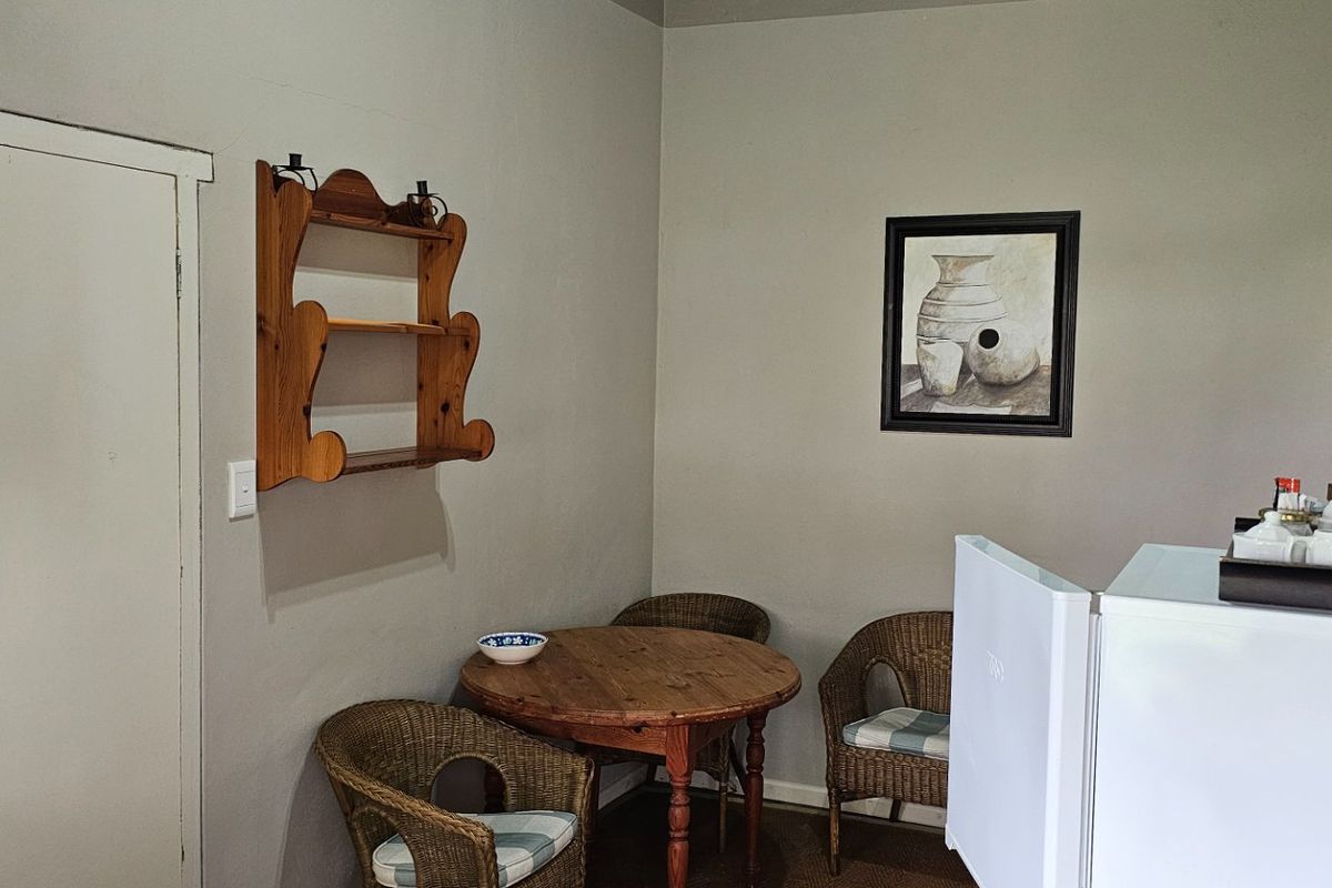 A compact kitchen area featuring neutral wall tones, built-in shelving, and functional access to adjacent spaces.