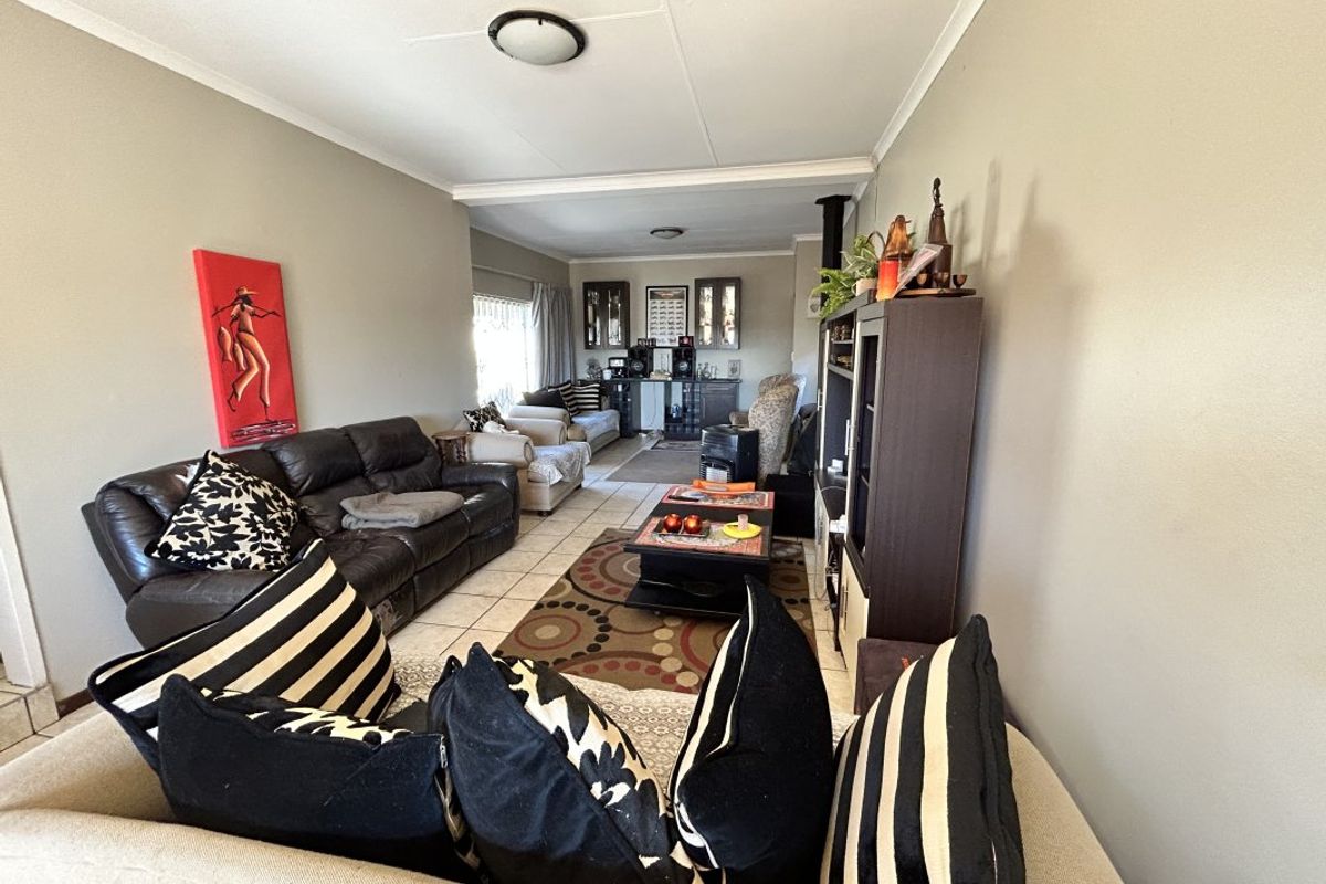 A spacious living room featuring tiled flooring and built-in cabinetry, offering a functional layout with neutral wall tones.
