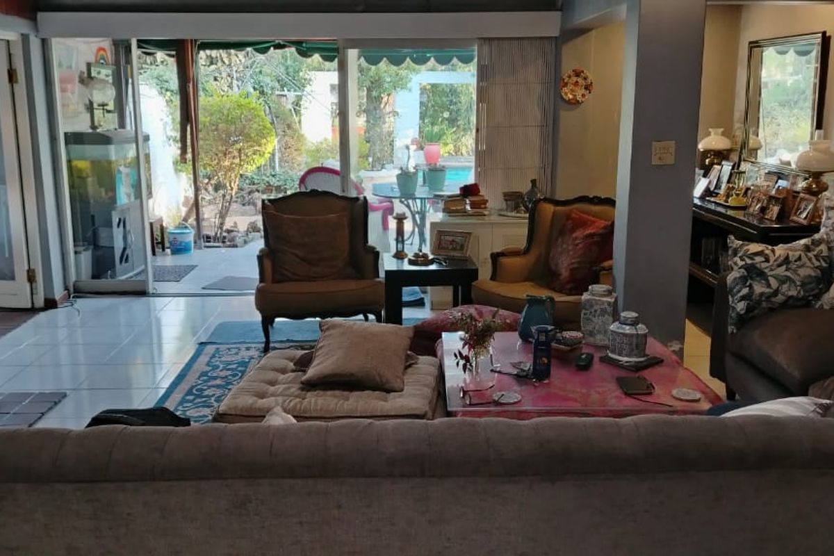 Spacious living room featuring a fireplace and large sliding glass doors that provide direct access to the outdoor patio and pool area.