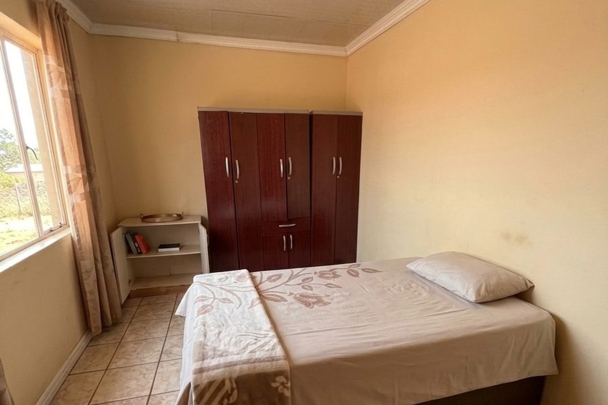 A bedroom featuring tiled flooring, a built-in wardrobe, and ceiling cornice. The room requires cosmetic updates to improve its overall condition.