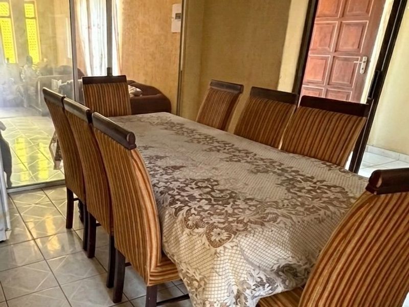 A dining area featuring tiled flooring, a coved ceiling, and a sliding glass door providing access to an adjacent space.