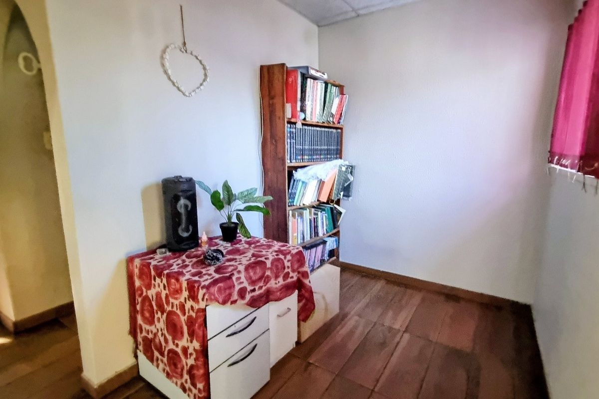 A small bedroom featuring timber flooring and neutral wall finishes, offering a blank canvas for potential renovation or restyling.