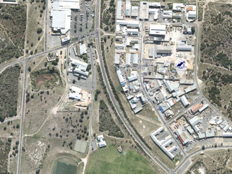 Aerial view of an industrial park showing the layout of various commercial buildings, road infrastructure, and surrounding landscape.