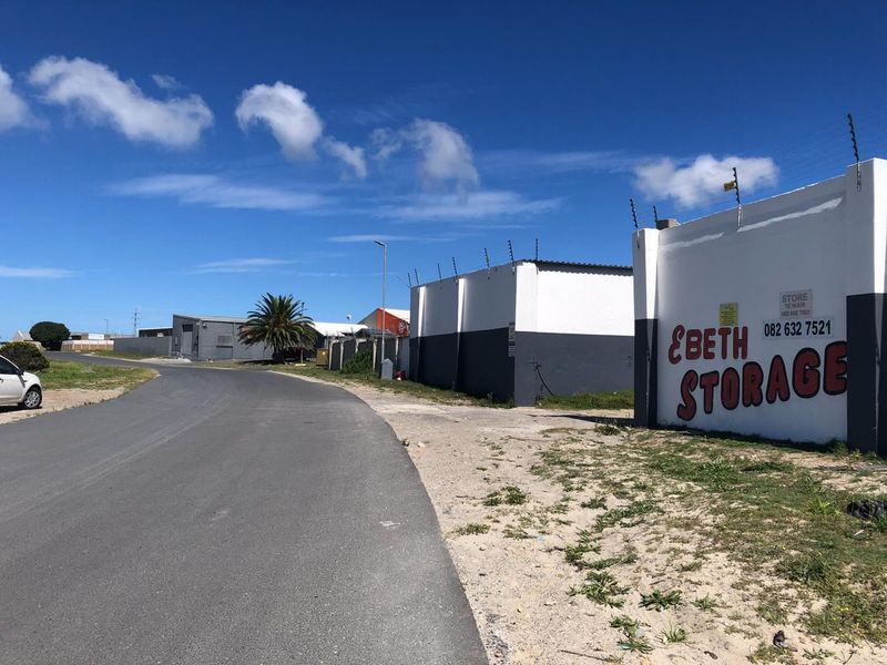 Street view of an industrial storage facility featuring perimeter walls with electric fencing and clear signage.
