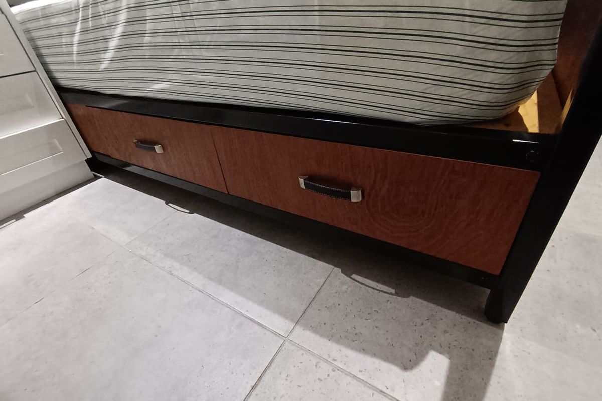 Close-up view of bedroom flooring and bed base with integrated storage drawers.
