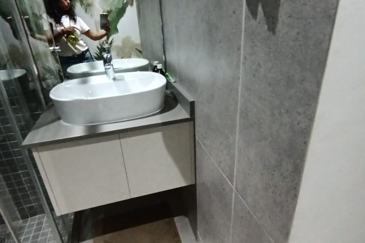 Modern bathroom featuring a vessel sink on a wall-mounted vanity, glass shower enclosure, and contemporary grey wall tiling.