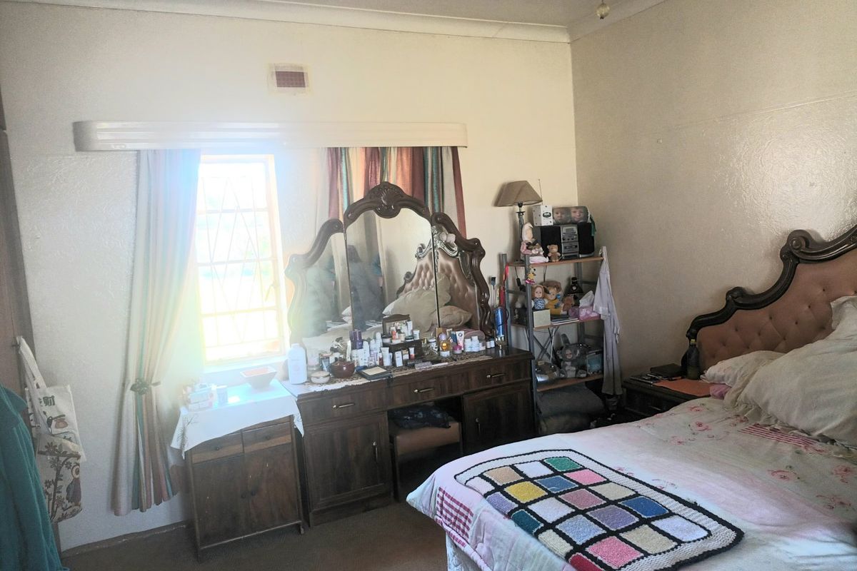 A standard bedroom featuring neutral walls, coving, and a ventilation grille, providing a functional space ready for modernization.