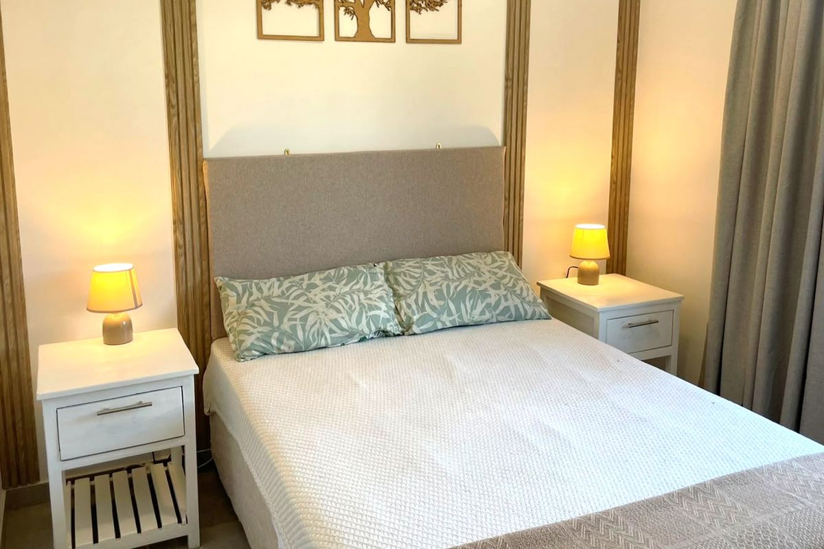 A well-maintained bedroom featuring decorative vertical wood wall paneling and neutral finishes, creating a cozy and inviting atmosphere.