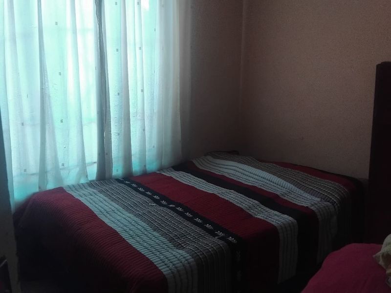 A bedroom featuring a window with curtains, providing natural light to the space.
