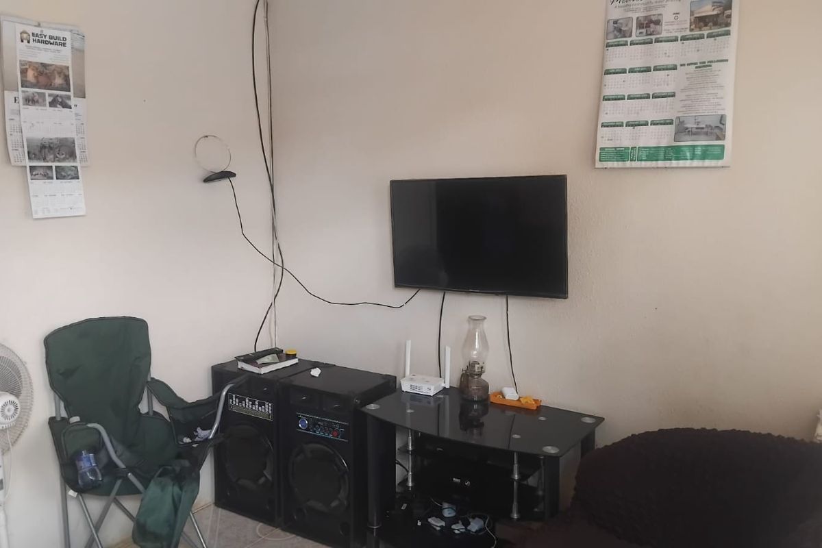 A living room area featuring a wall-mounted television with visible wiring, providing a functional space for entertainment.