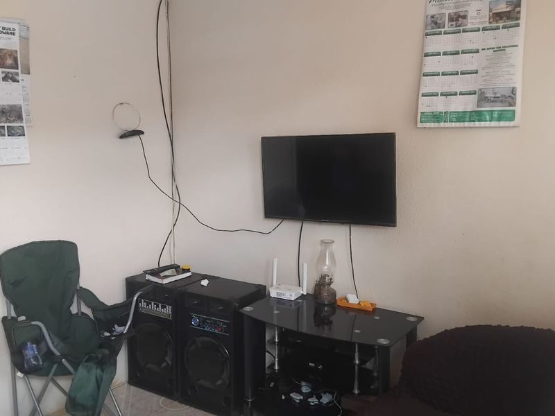 A living room area featuring a wall-mounted television with visible wiring, providing a functional space for entertainment.