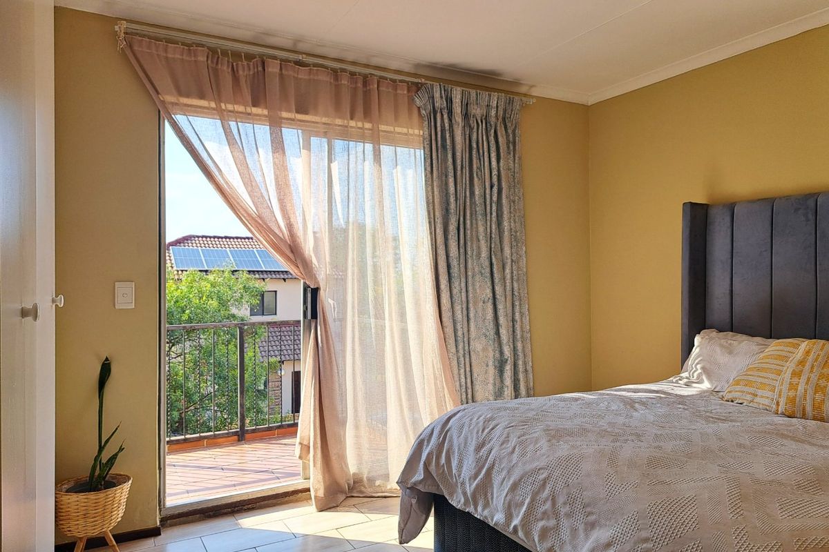 A bedroom featuring tiled flooring and a sliding glass door that provides direct access to a private balcony.